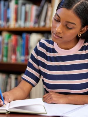 Your mind is a weapon, use it for good. Shot of a young woman studying in a college library